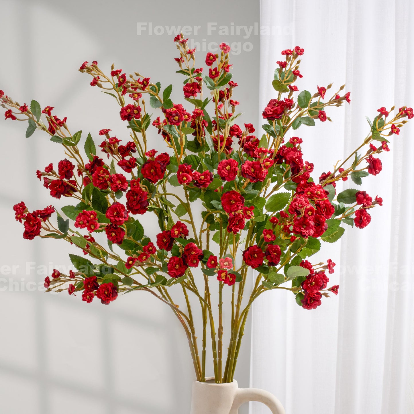 Red faux miniature rose stems in a vase