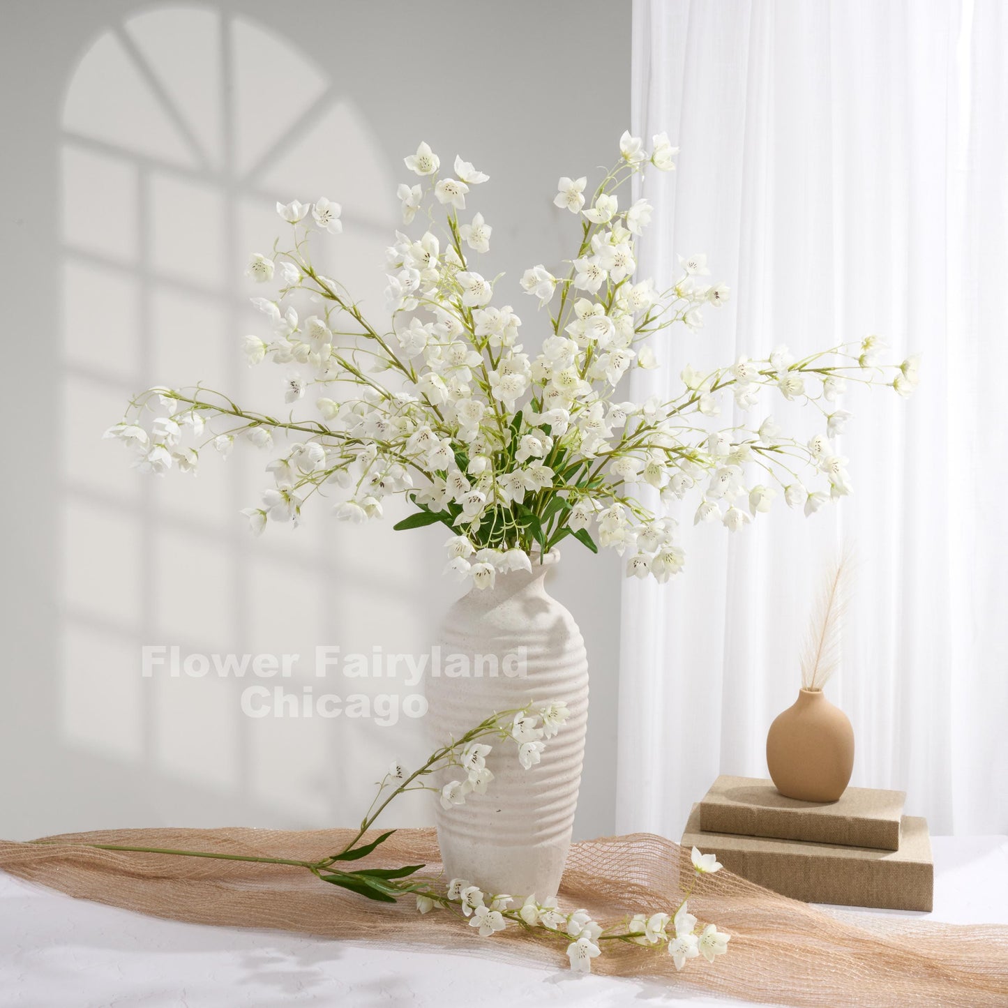 White faux Enkianthus stems held in hand