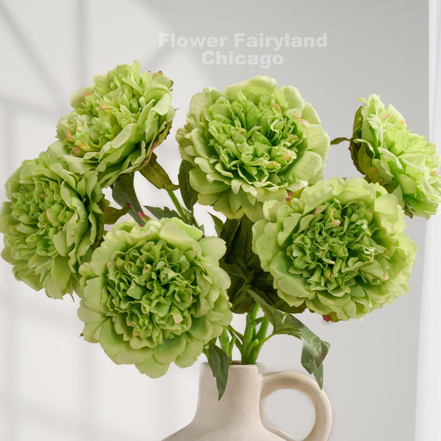 Green real touch peony blooms arranged in a vase
