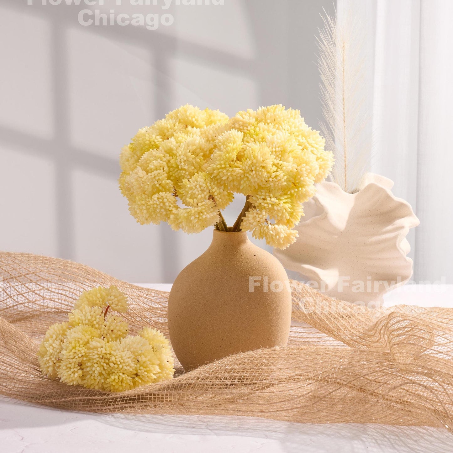 Yellowish cream sedum clusters styled in a vase