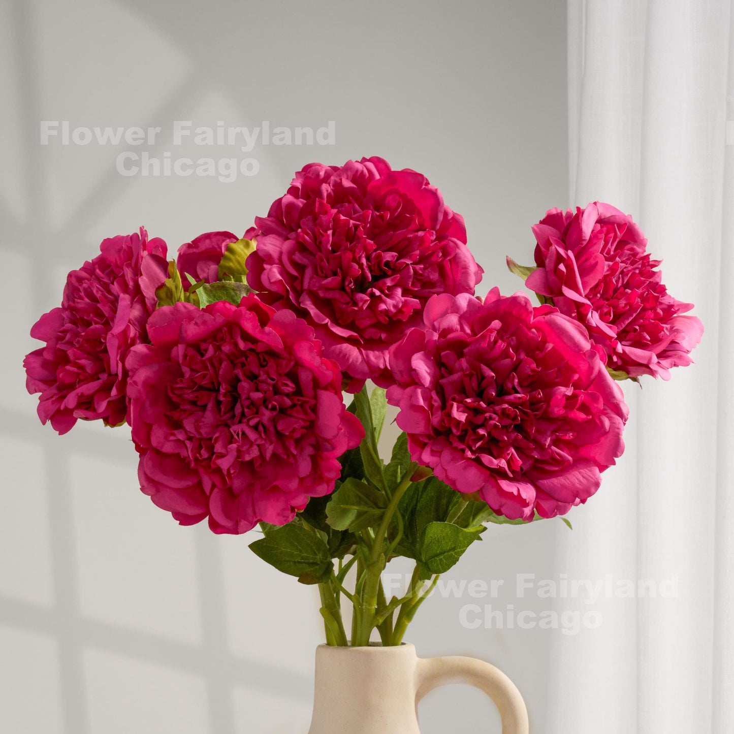 Raspberry real touch peonies arranged in a cream vase