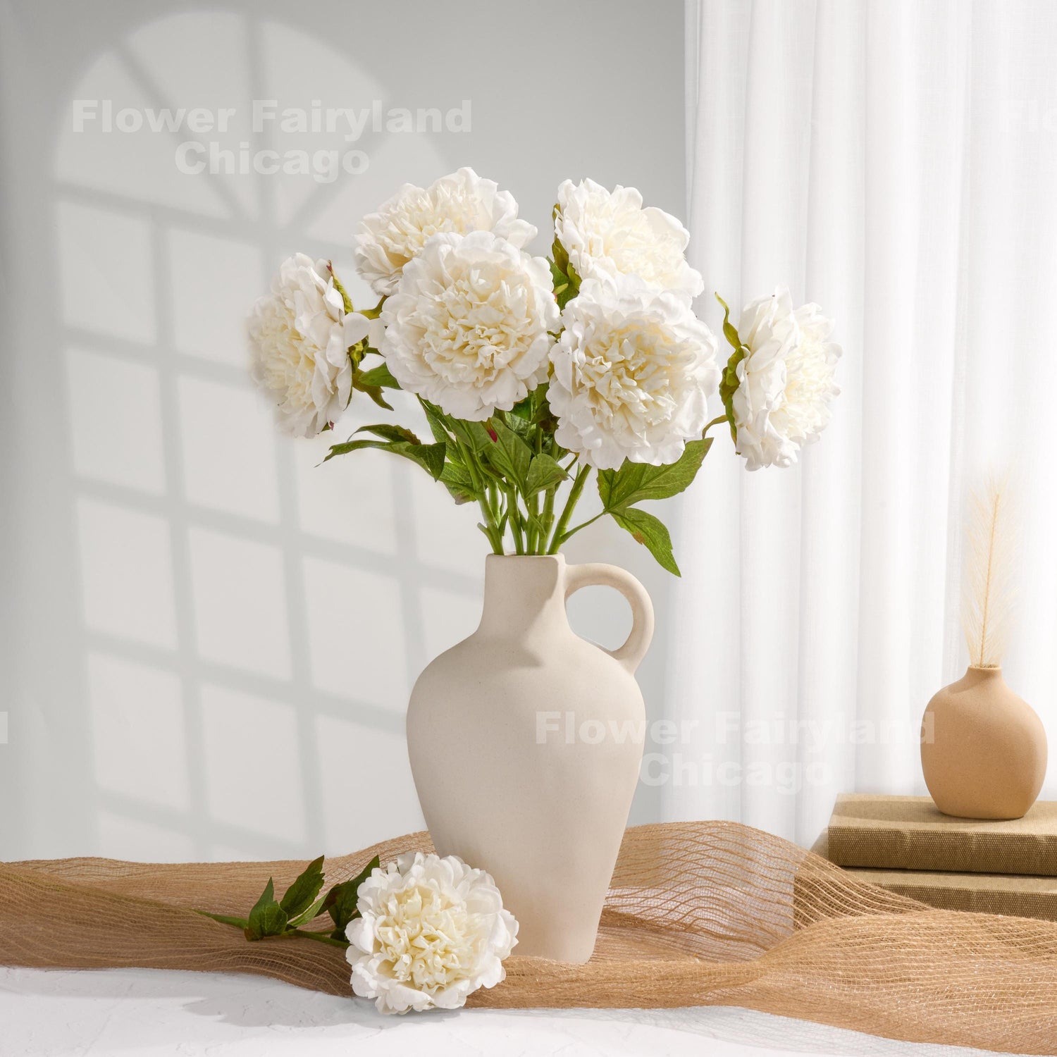 White faux peonies styled in a home decor scene