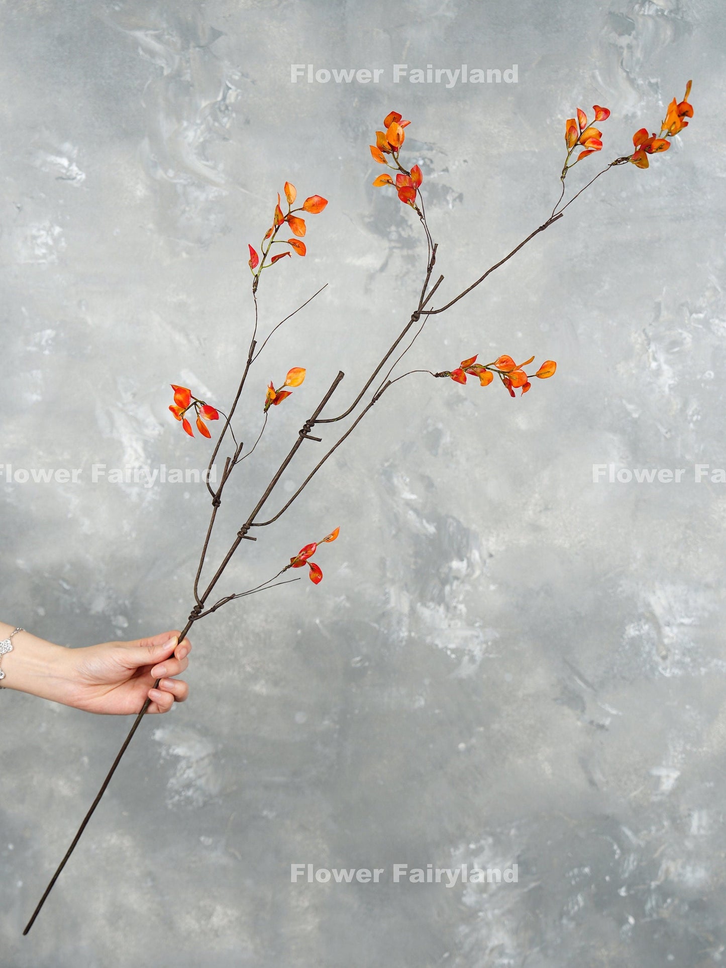 Single 39 inch orange leaf branch stem held in hand