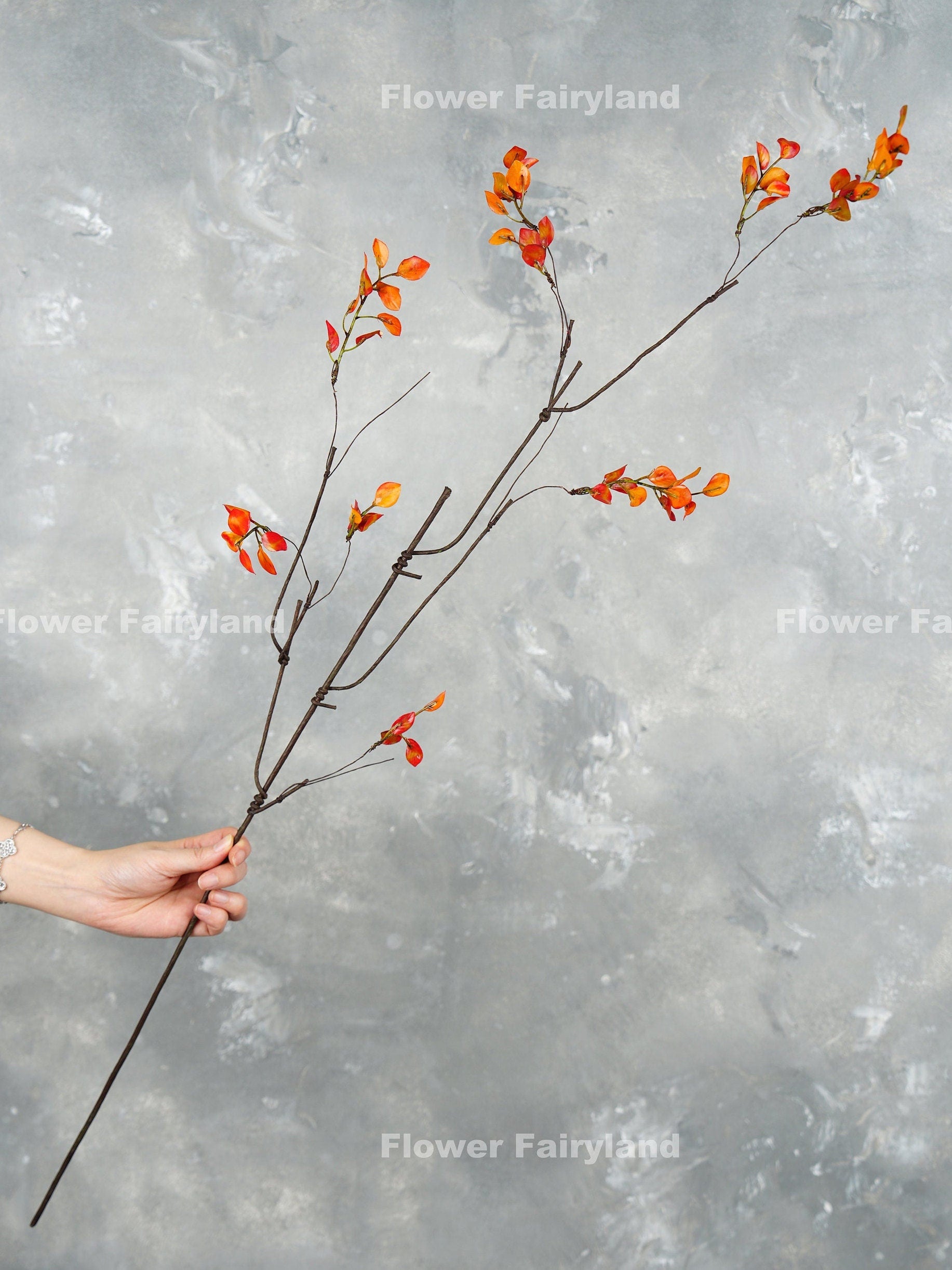 Single 39 inch orange leaf branch stem held in hand