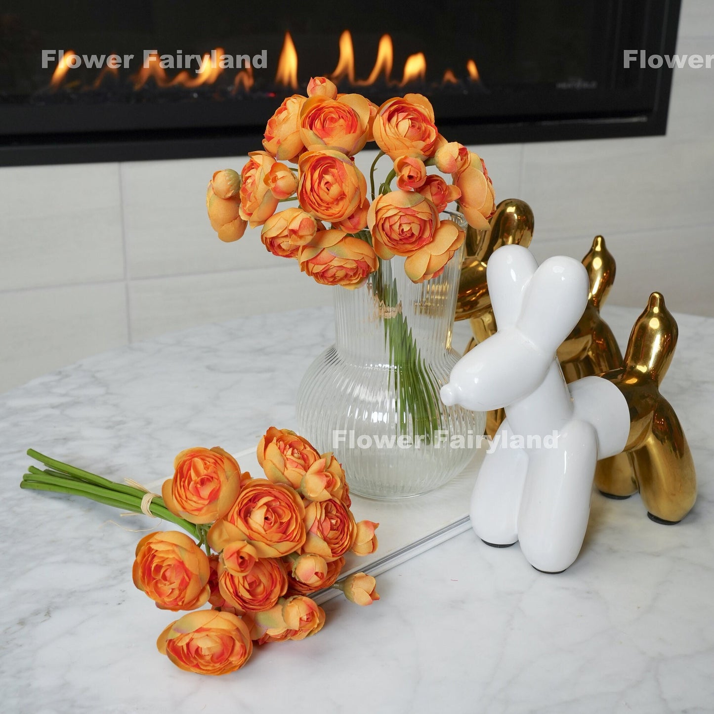 Gradual orange mini ranunculus styled in a vase