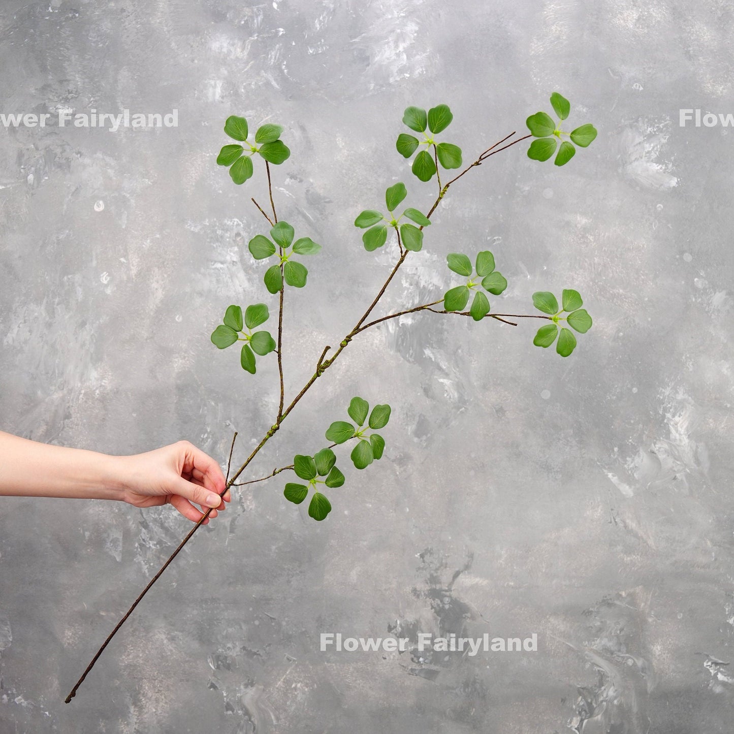 Faux Pieris Japonica stem held in hand for scale
