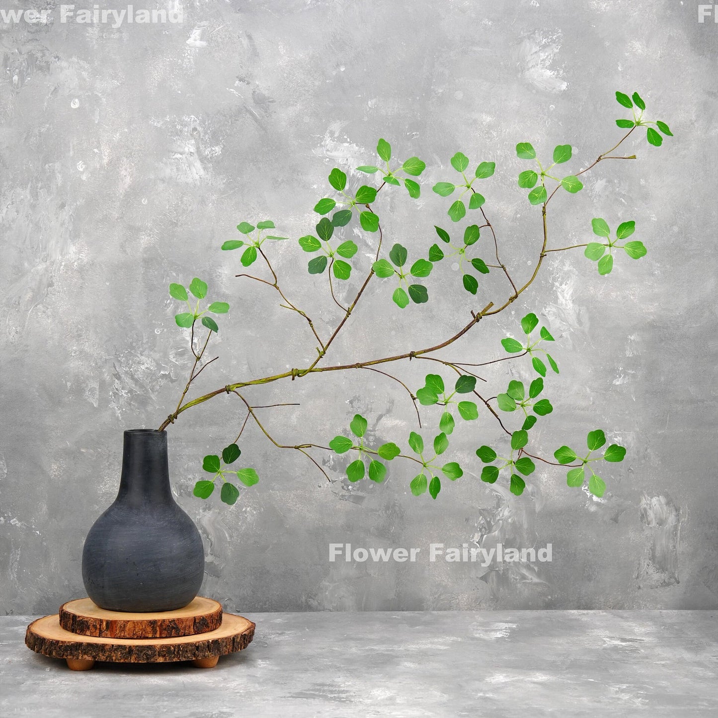 Faux Pieris Japonica stem arching from a vase