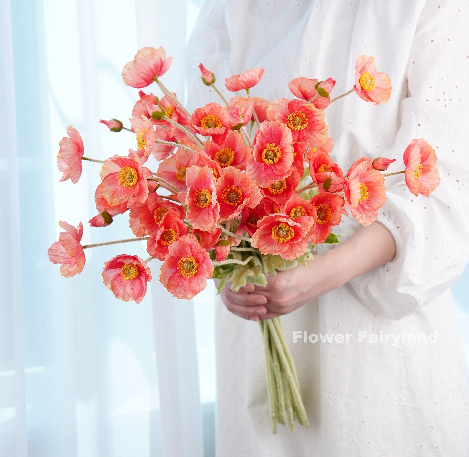 Reddish salmon faux poppy bouquet in hand