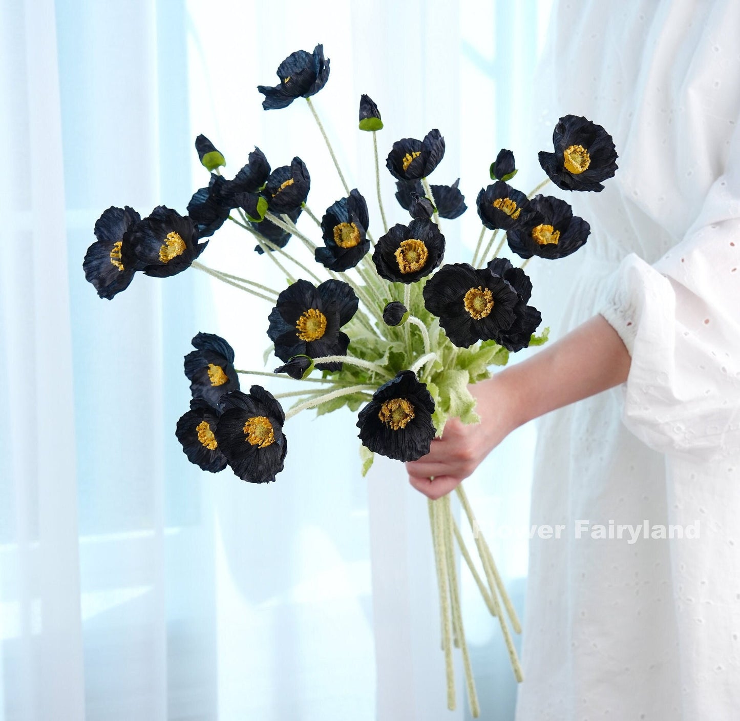 Black faux poppy bouquet held in hand