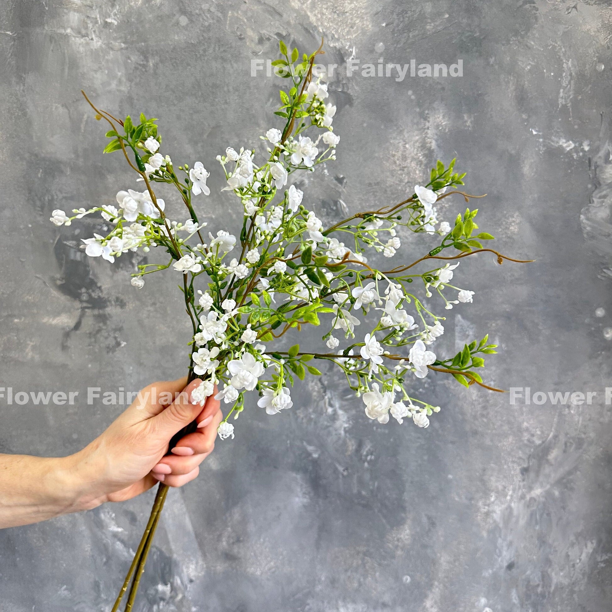 Faux wax flower stem in white held in hand