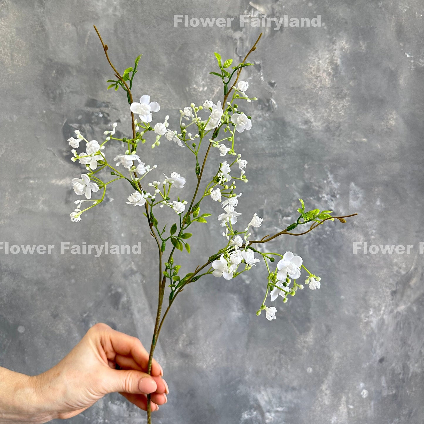 White faux wax flower held in hand