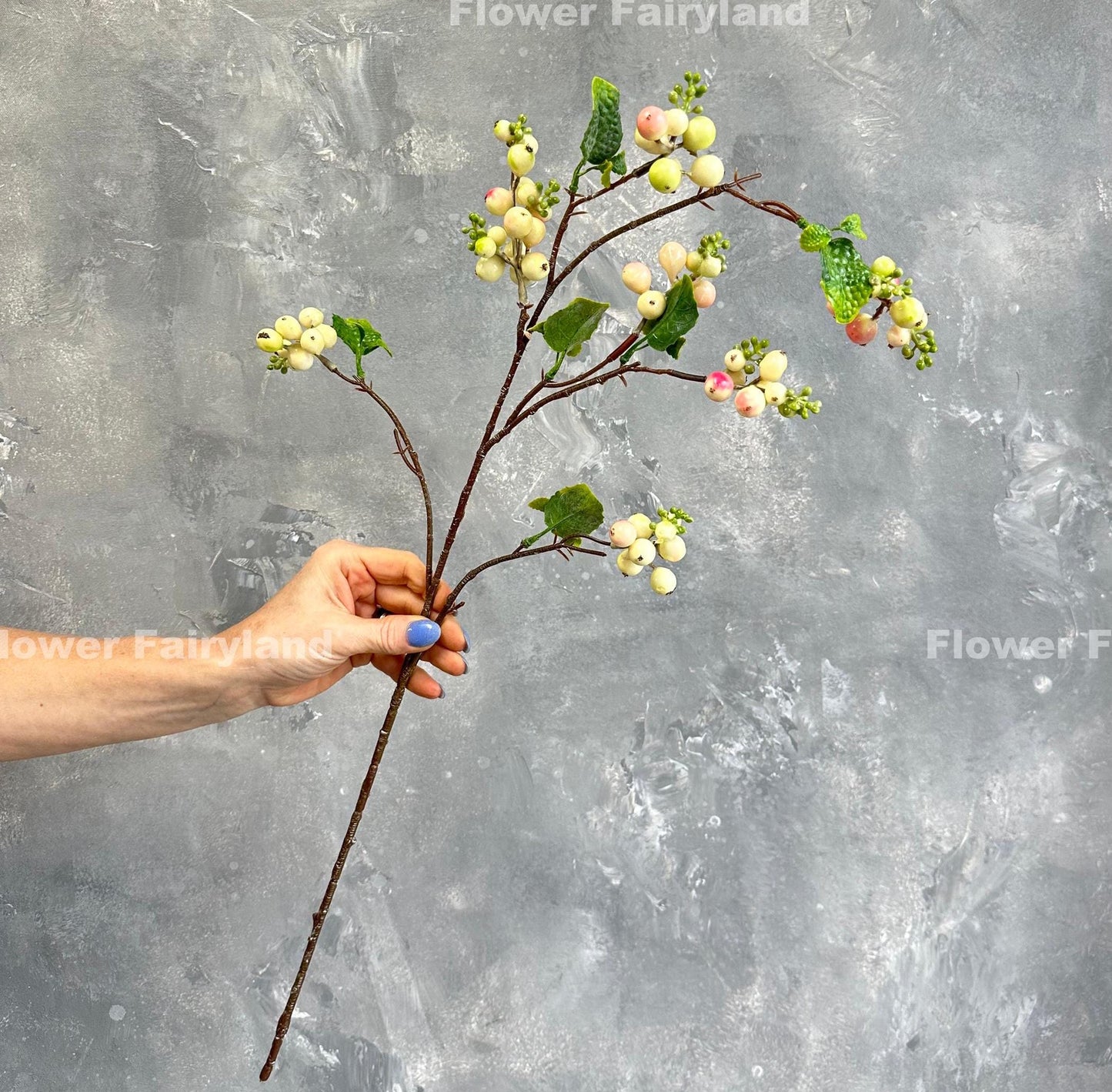 Pinkish green snowberry branch styled in vase