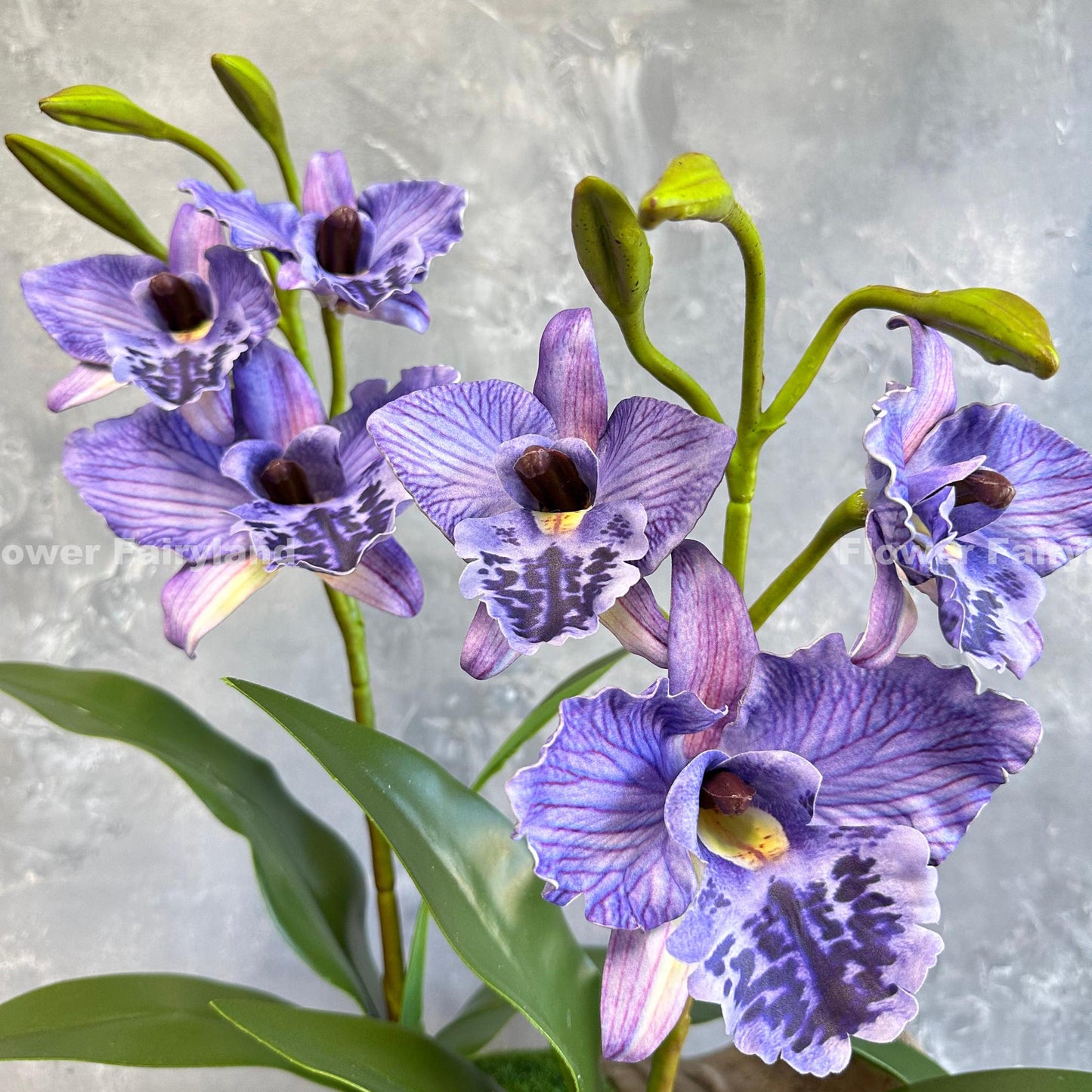Purple faux cattleya orchid held in hand