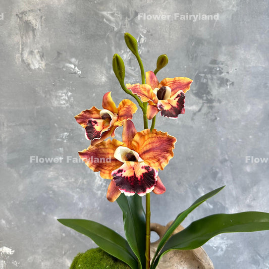 Faux cattleya orchid in dark reddish orange with leaves and roots