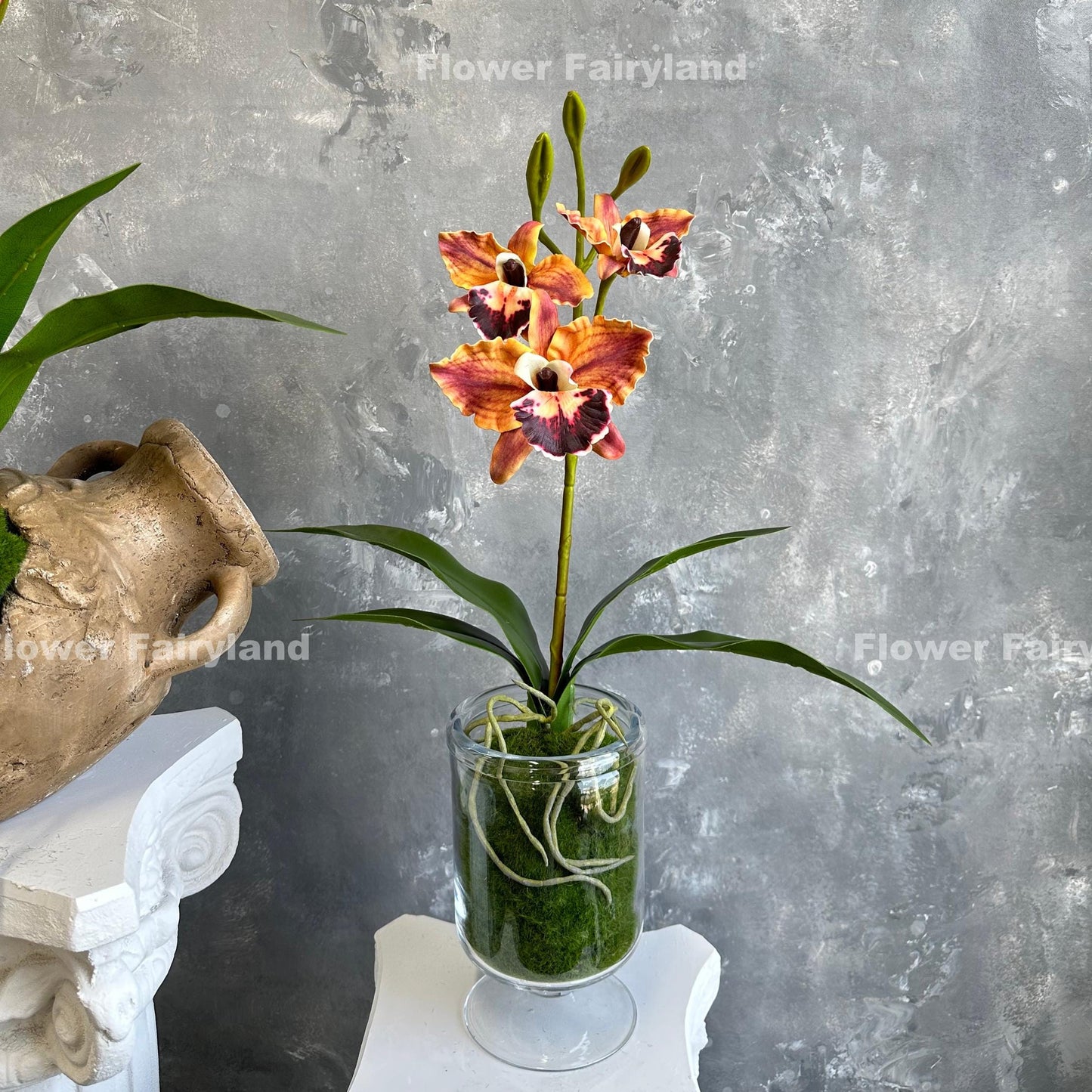 Dark reddish orange faux cattleya orchid held in hand