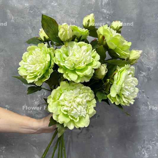 Lime green real touch peony stems held in hand