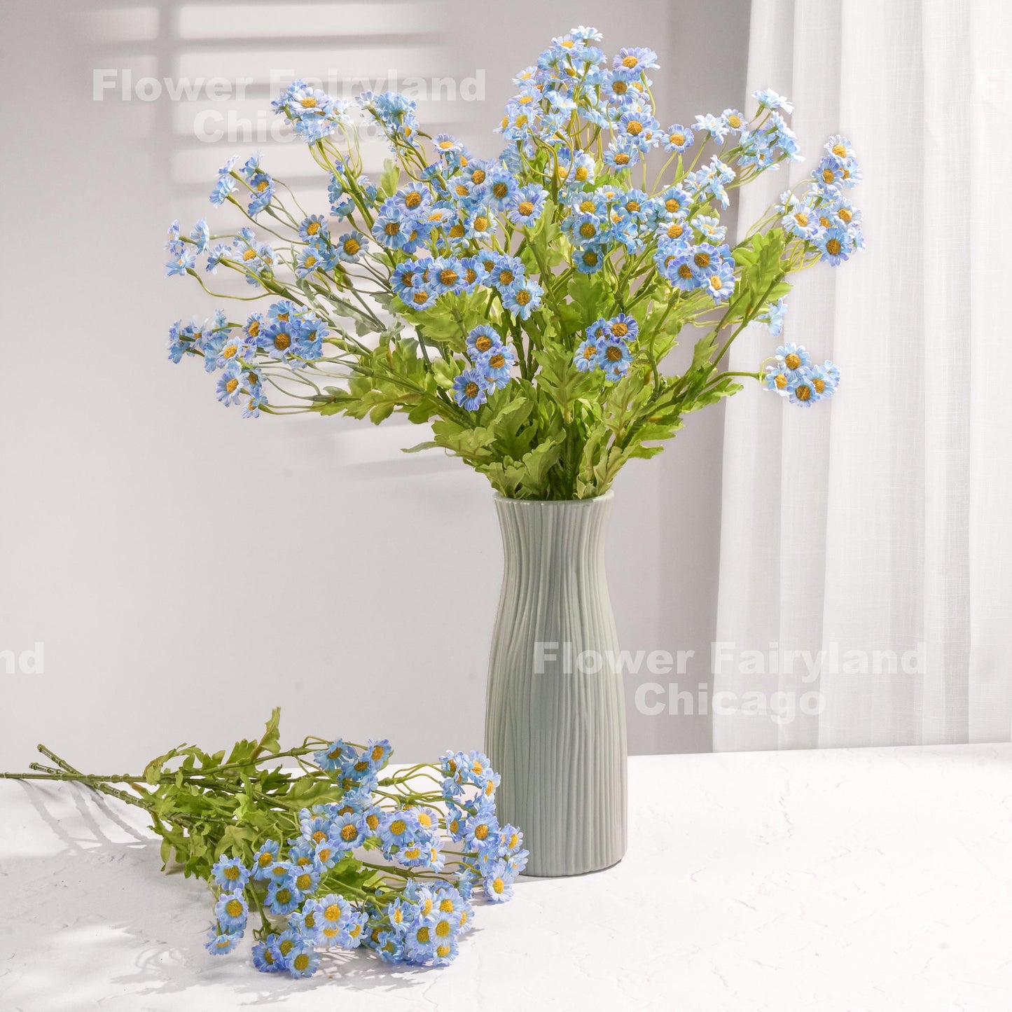Blue faux chamomile arrangement in a vase