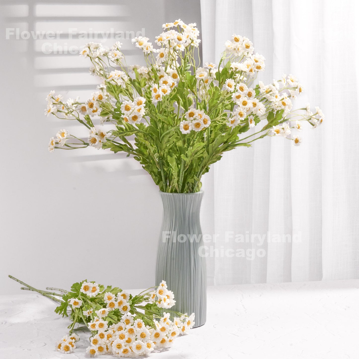 Bright white faux chamomile arrangement in a vase
