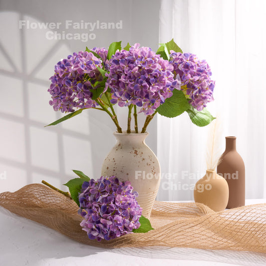 Purple faux hydrangea arrangement in a vase