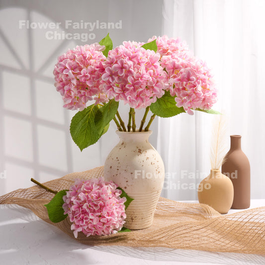 Pink faux hydrangea arrangement in a vase