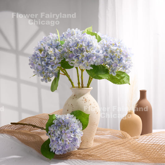 Light violet blue faux hydrangea arrangement in a vase