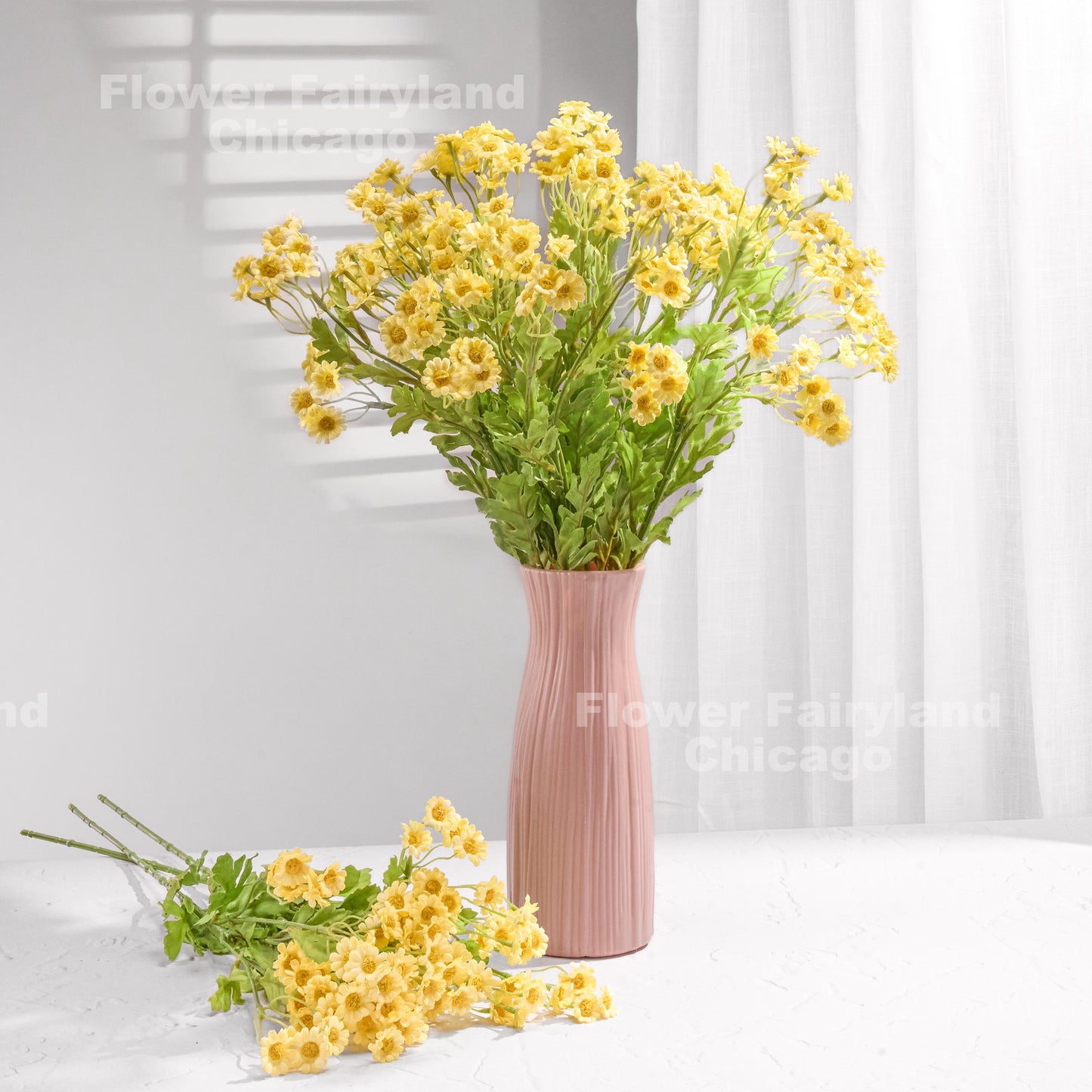 Yellow faux chamomile arrangement in a vase
