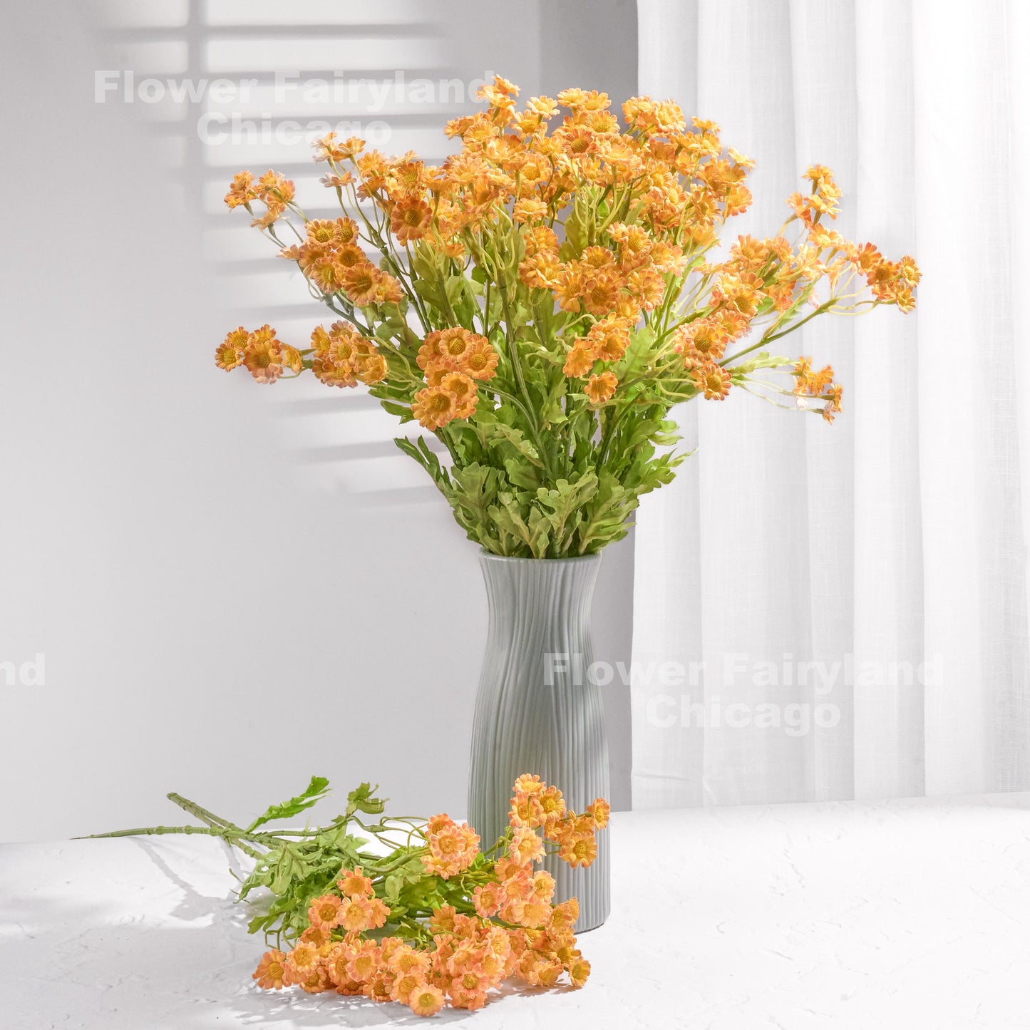 Orange faux chamomile arrangement in a vase