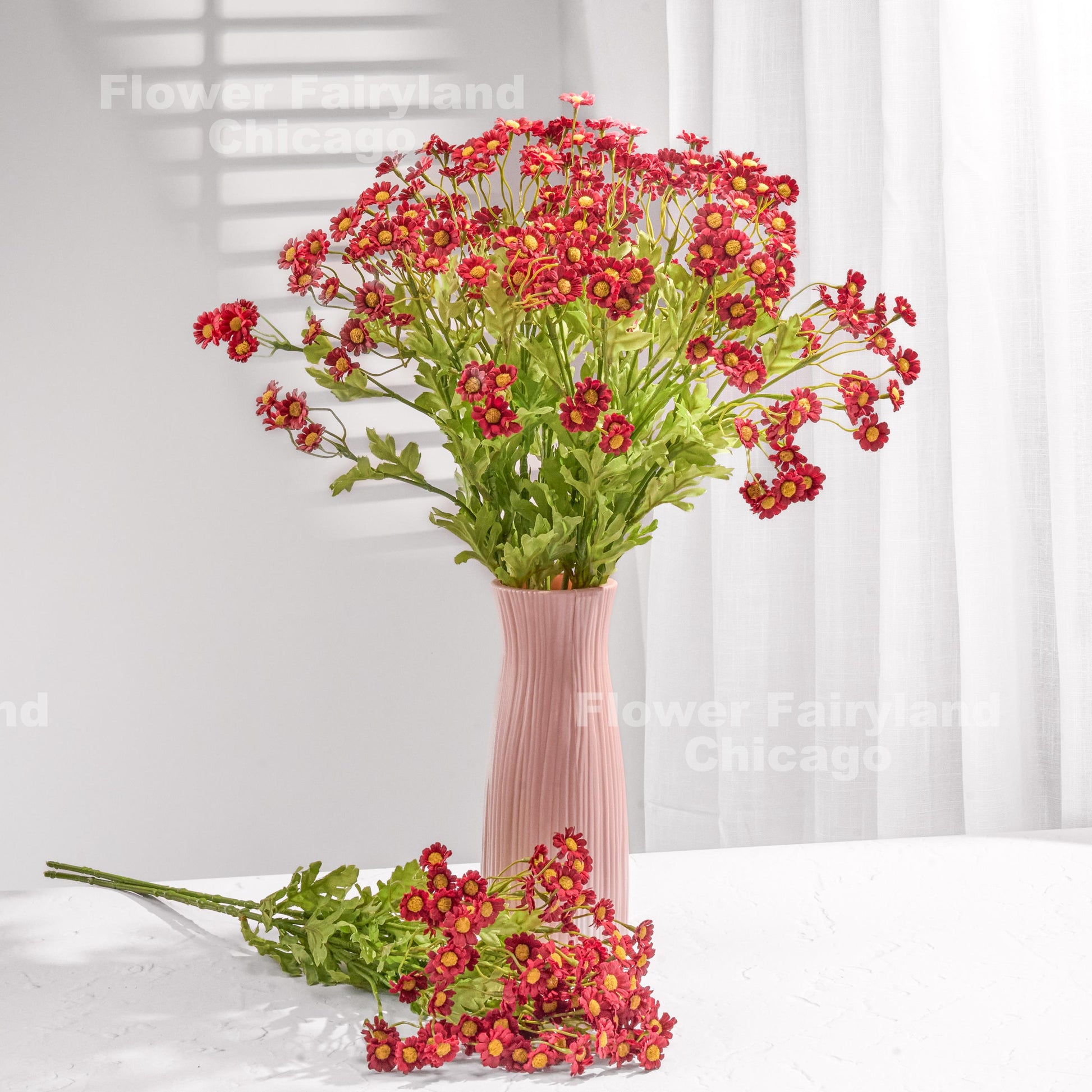 Red faux chamomile bouquet held in hand
