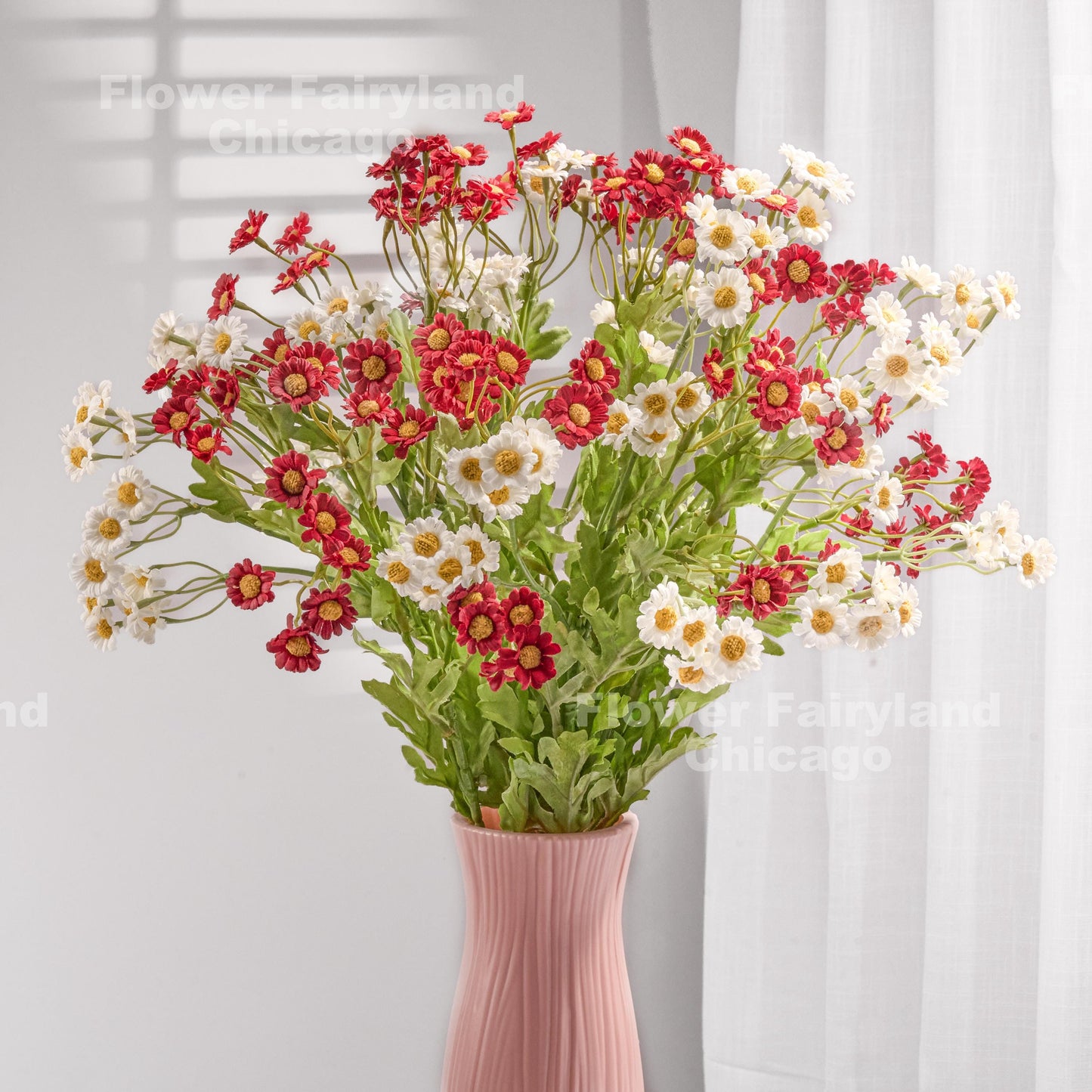Red faux chamomile arrangement in a vase