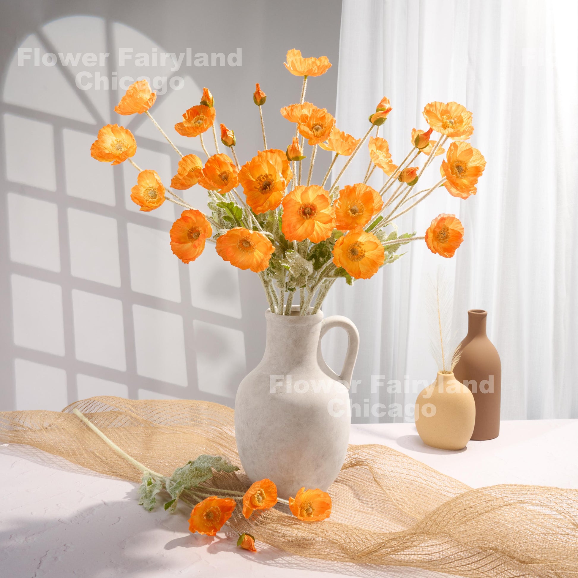 Orange faux poppy stems in a vase