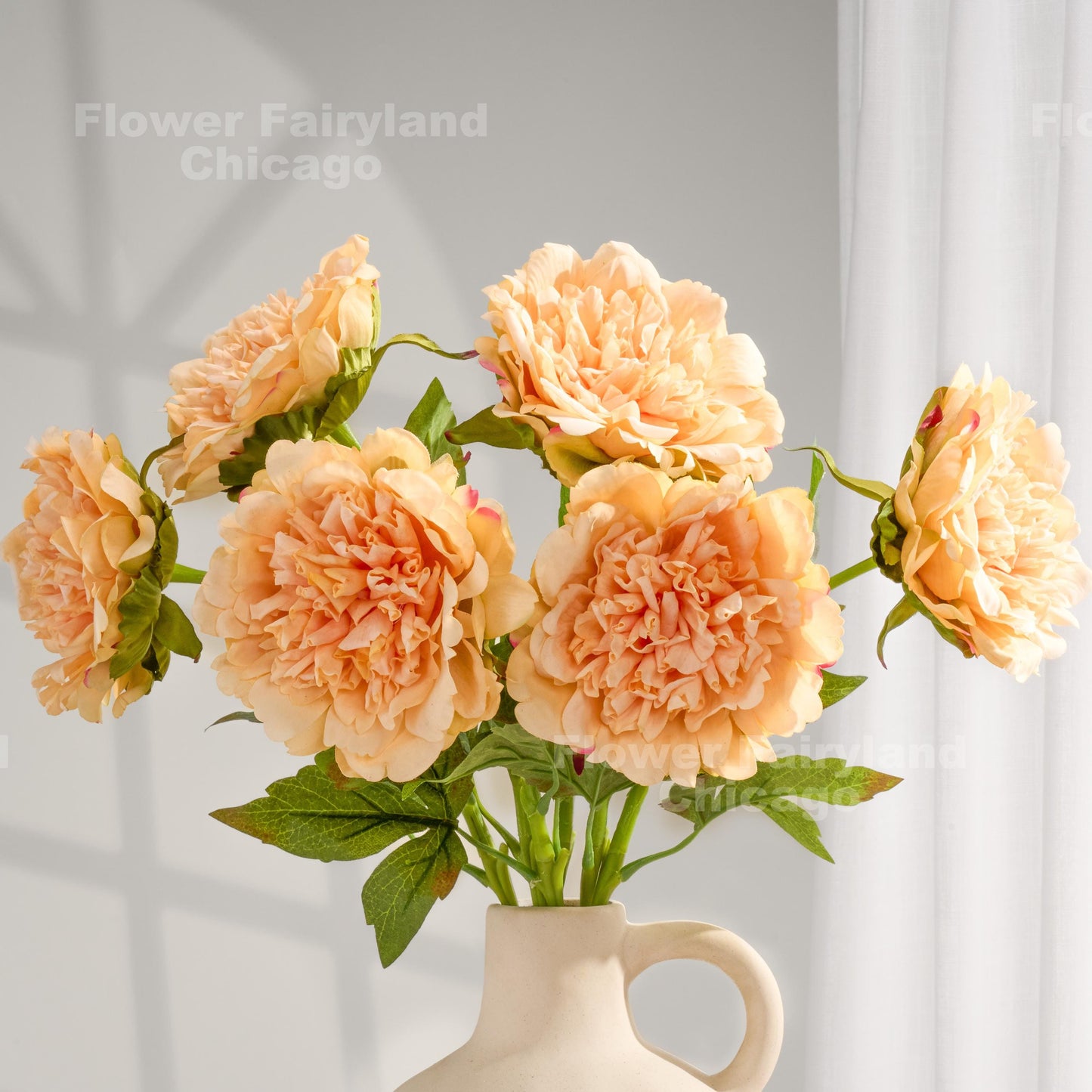 Peach real touch peonies arranged in a cream vase