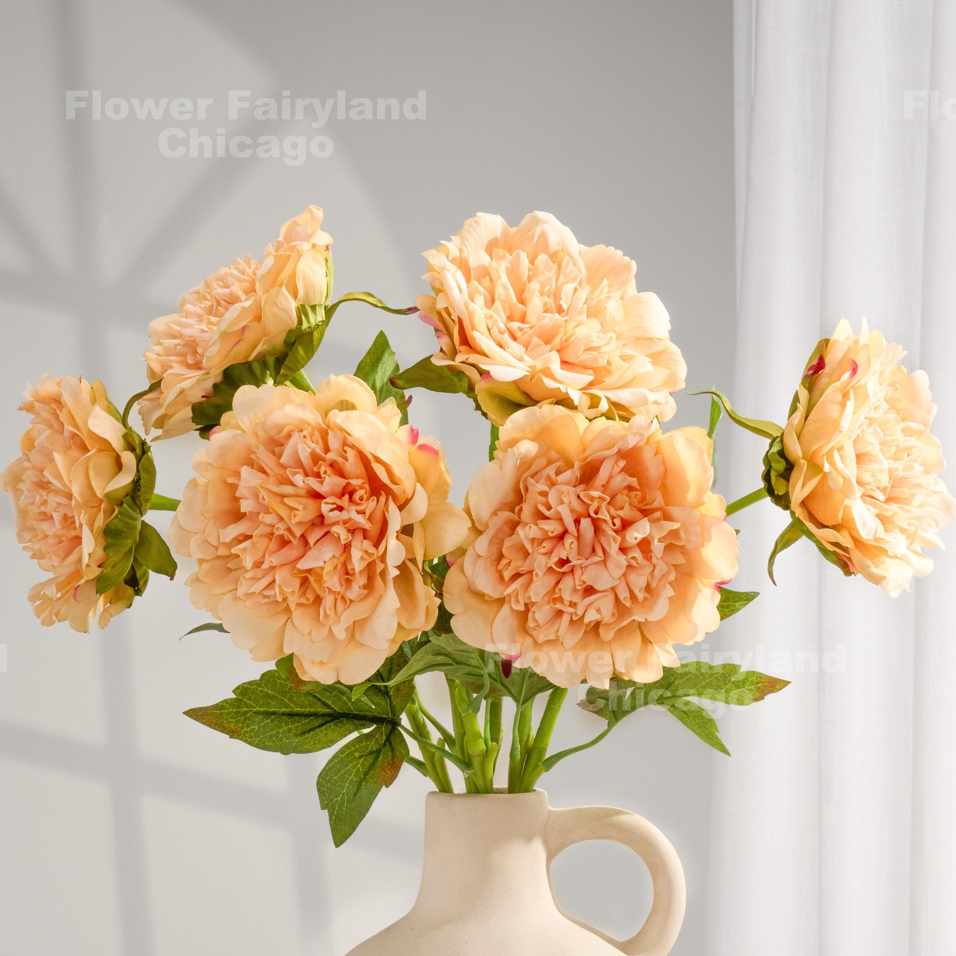 Peach real touch peonies arranged in a cream vase