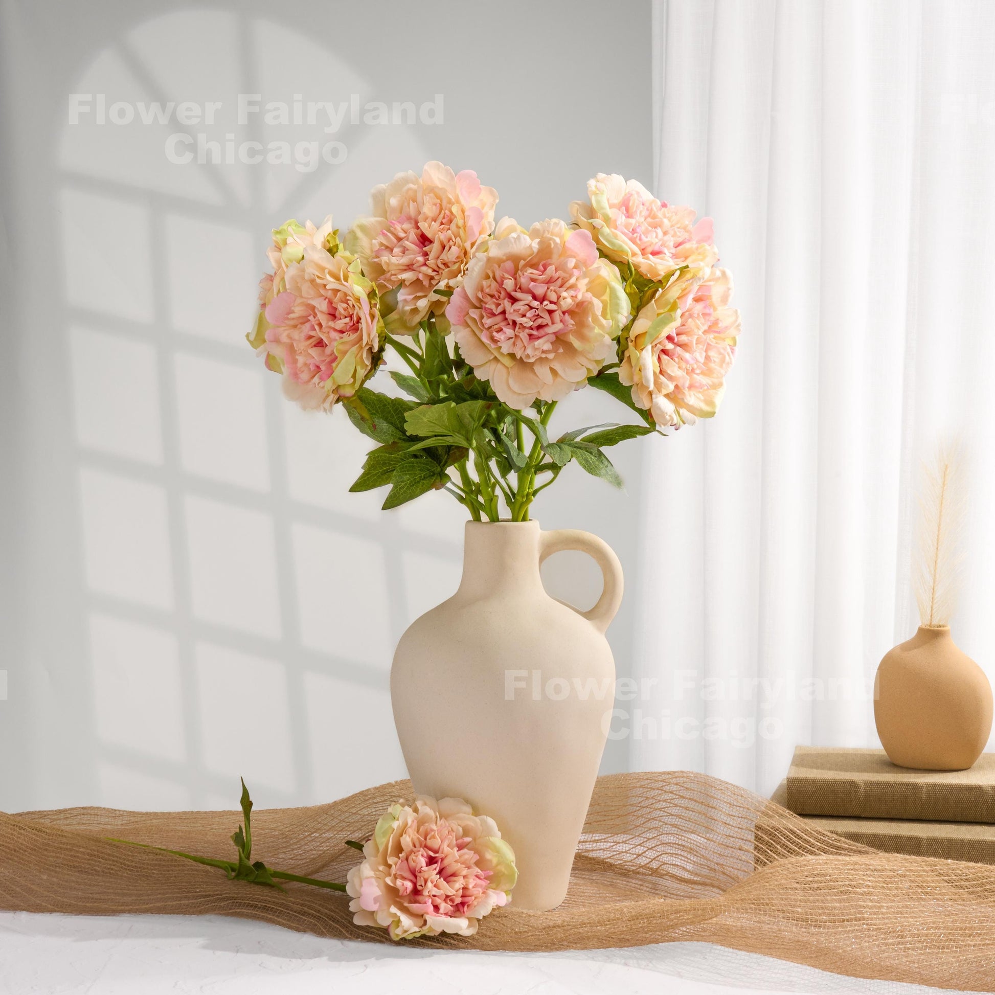 Pinky peach faux peonies styled in a home decor scene
