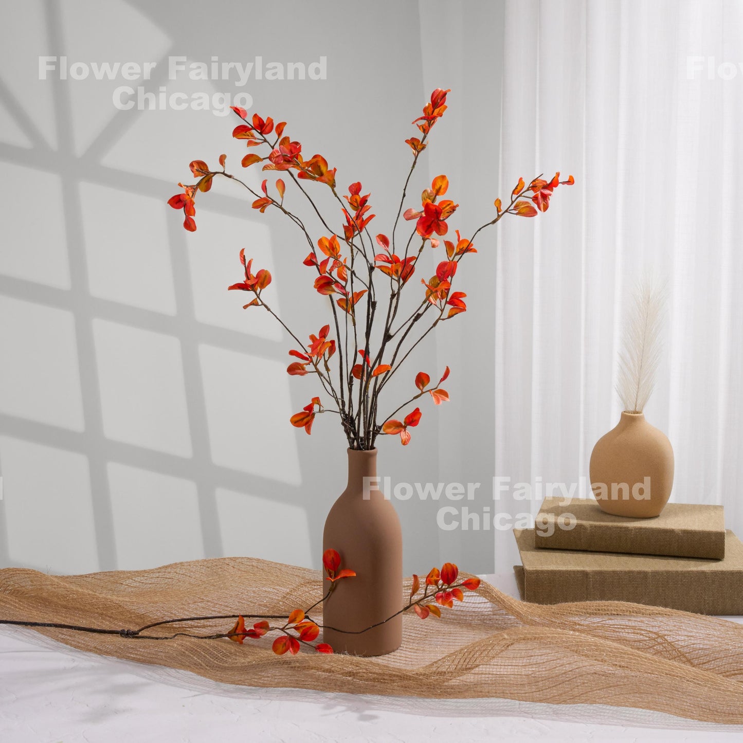 Orange minimalist leaf stems arrangement in a vase