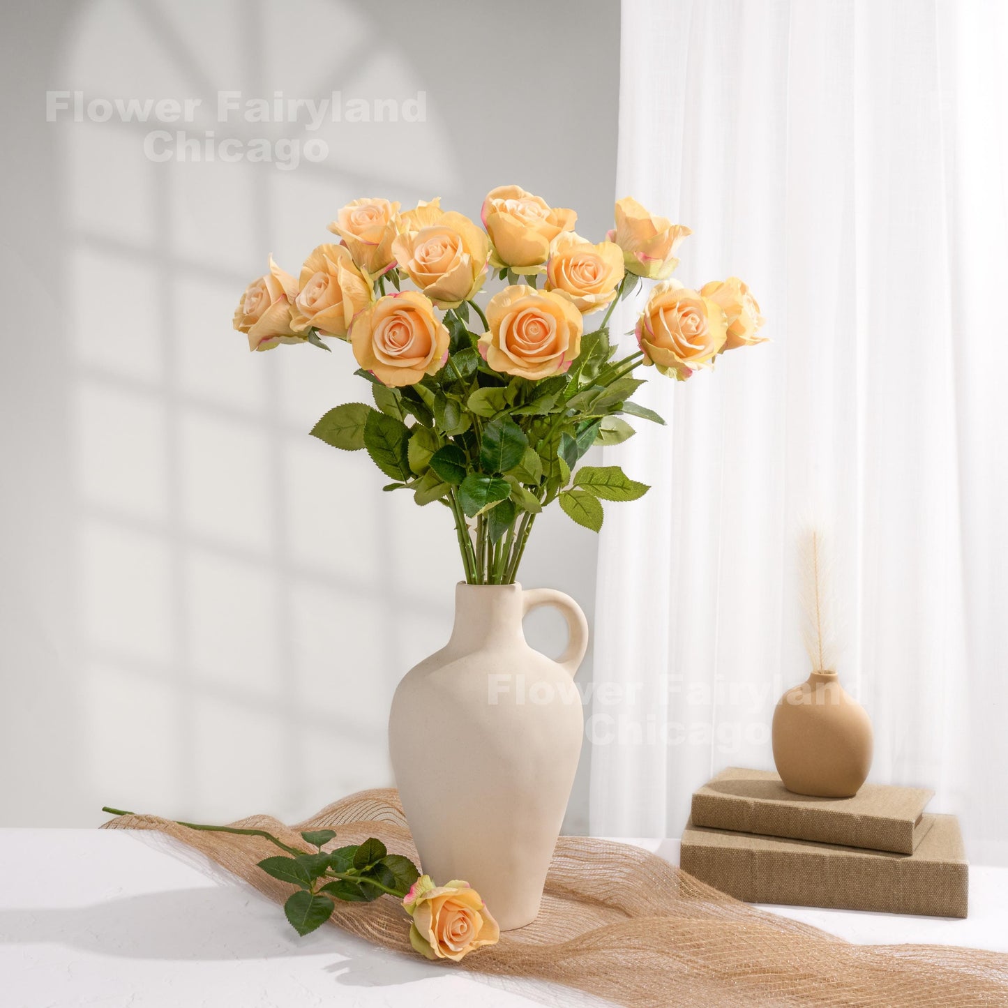 Greenish peach roses styled in a cream vase