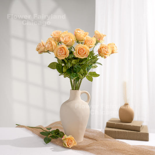 Greenish peach roses styled in a cream vase