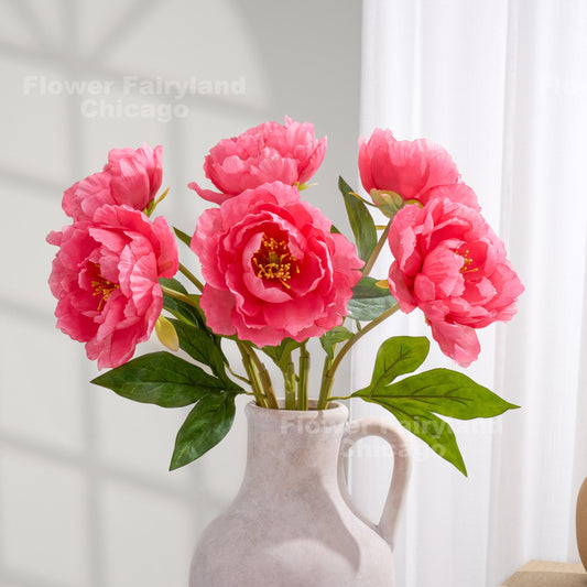Bright pink faux peonies styled in a pitcher vase
