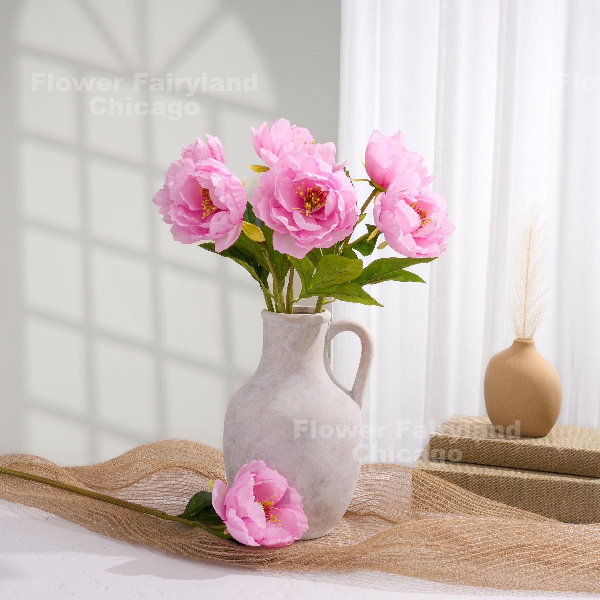 Pink faux peony arrangement in a pitcher vase