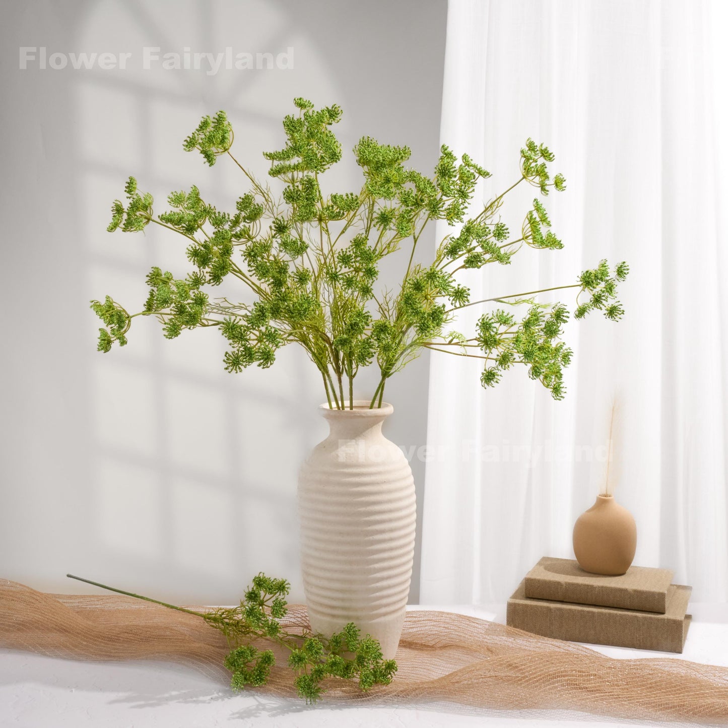 Green faux Queen Anne's lace arrangement in a white vase