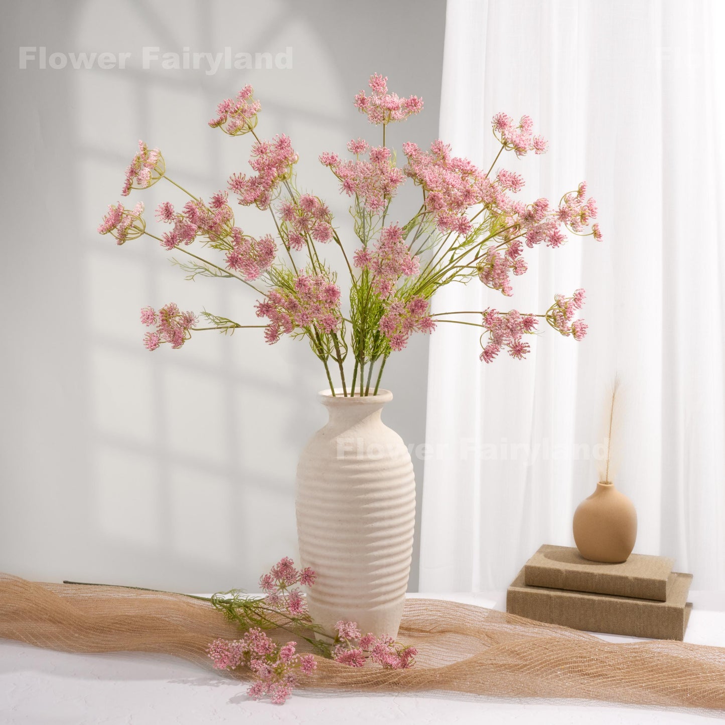Pink faux Queen Anne's lace arrangement in a white vase