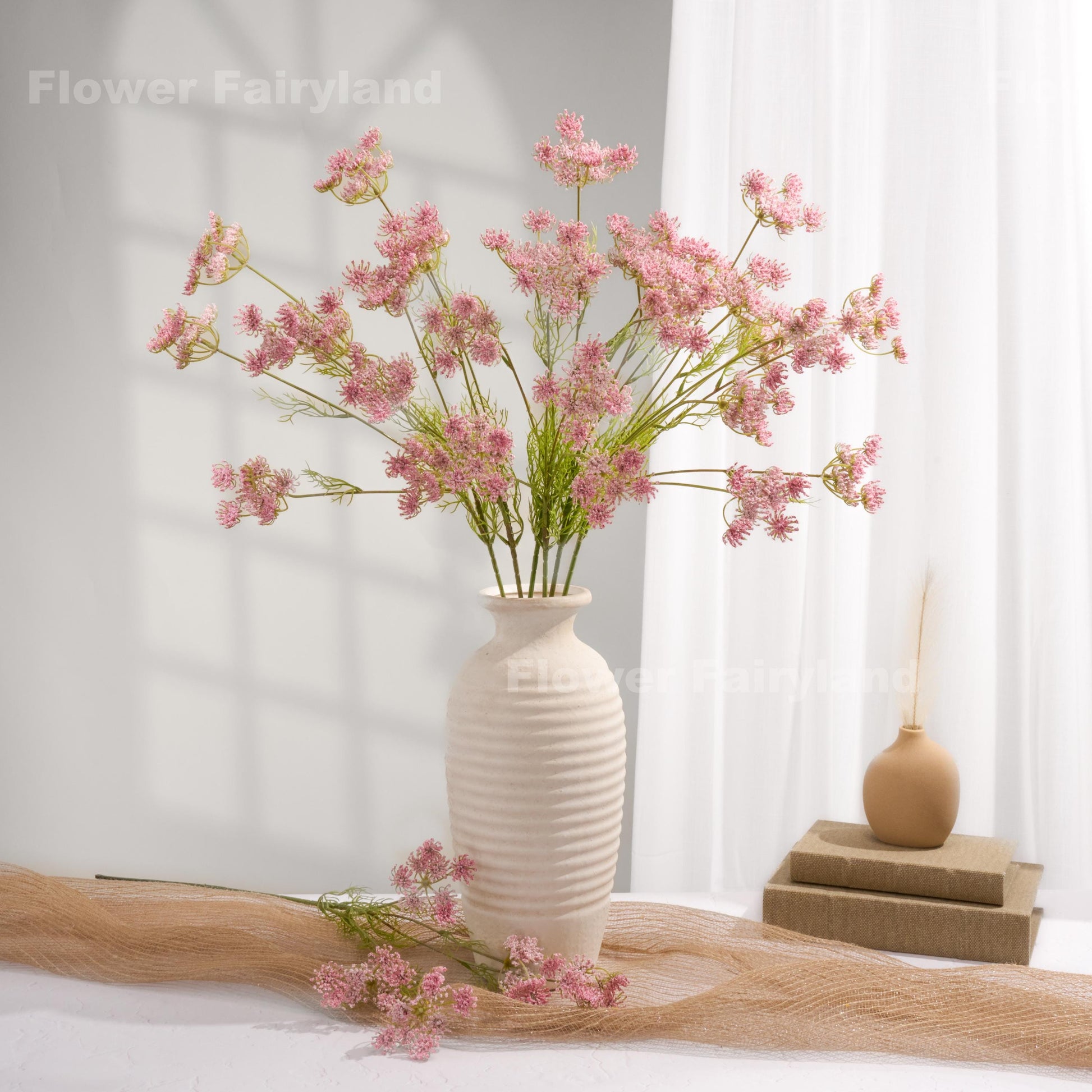 Pink faux Queen Anne's lace arrangement in a white vase