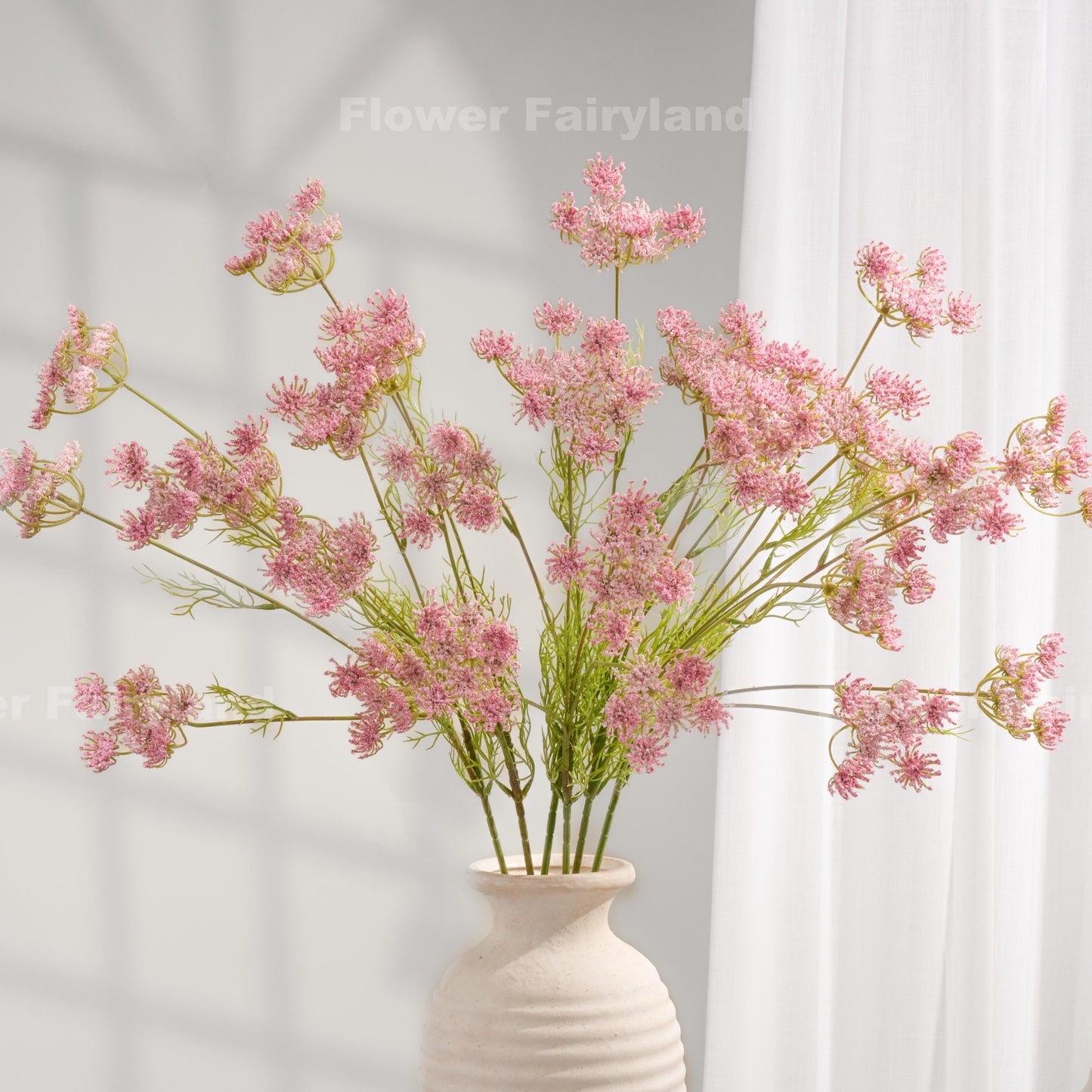Pink faux Queen Anne's lace stems styled in a vase