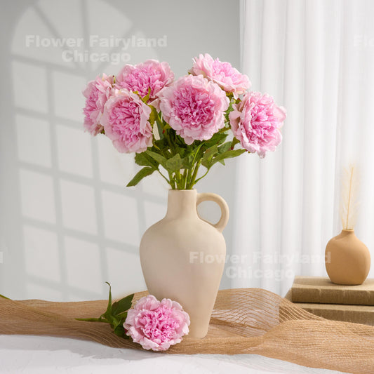 Light pink faux peonies styled in a home decor scene