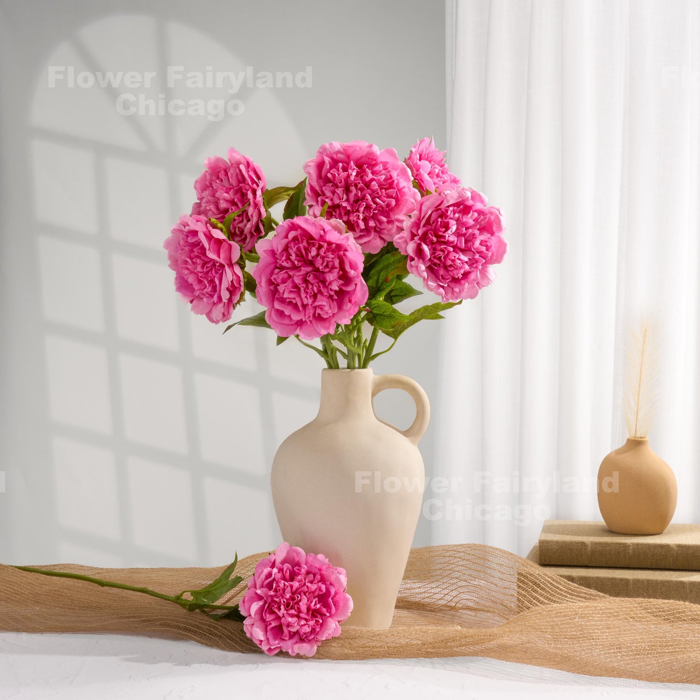 Pink faux peonies styled in a home decor scene
