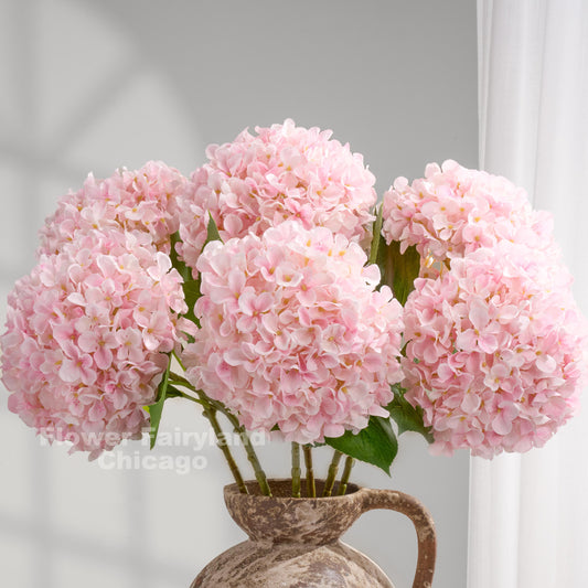 Light pink faux hydrangeas styled in a pitcher vase