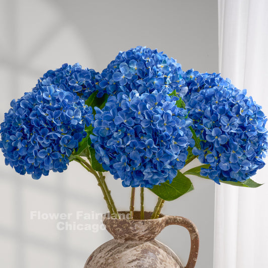 Blue faux hydrangeas styled in a pitcher vase