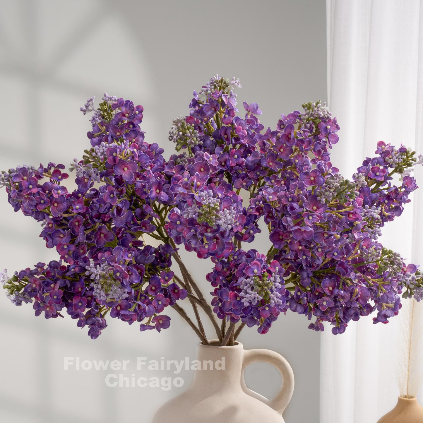 Dark purple real touch lilac stems in a vase