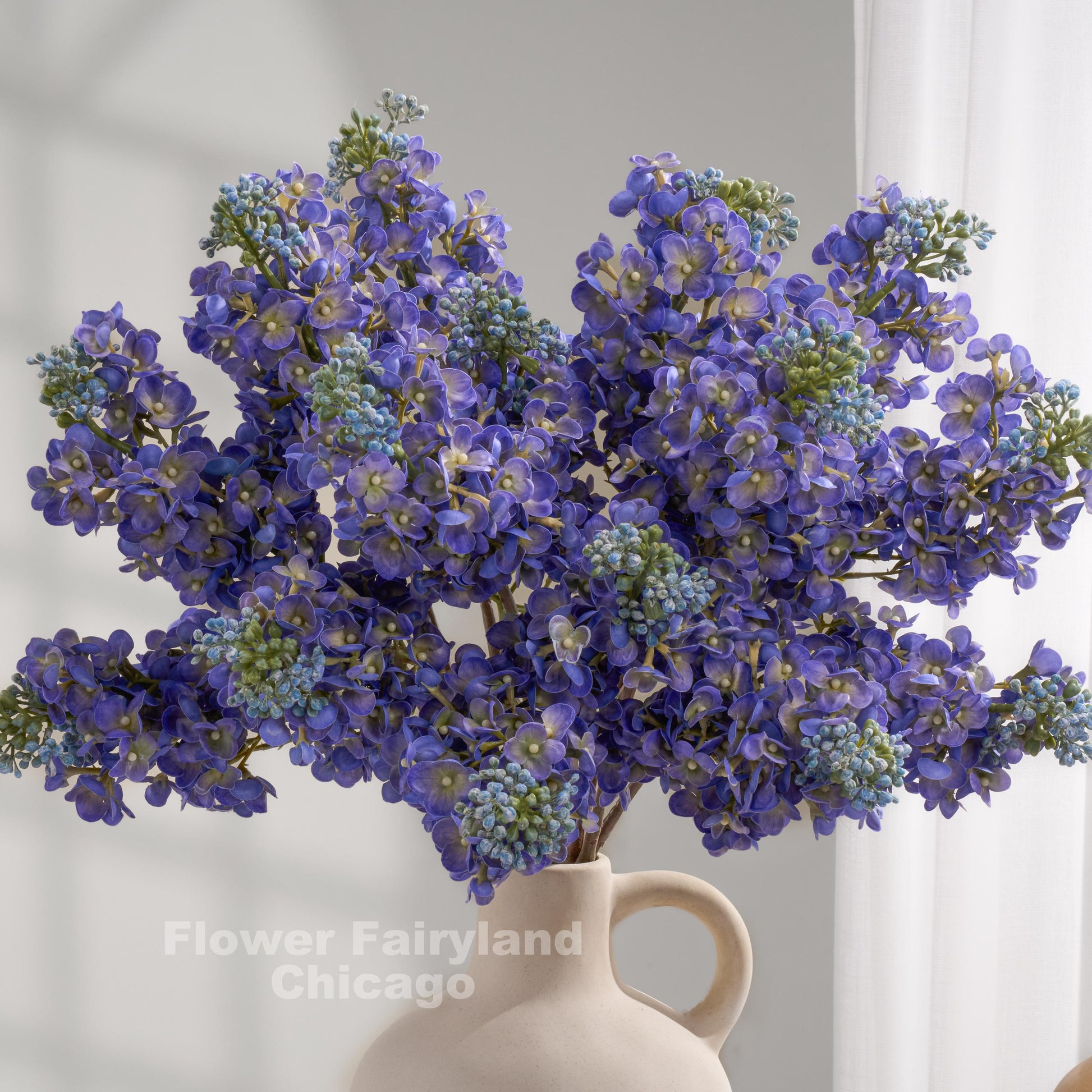 Blue real touch lilac stems in a vase