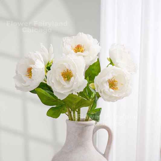 White faux peony arrangement in a clear vase