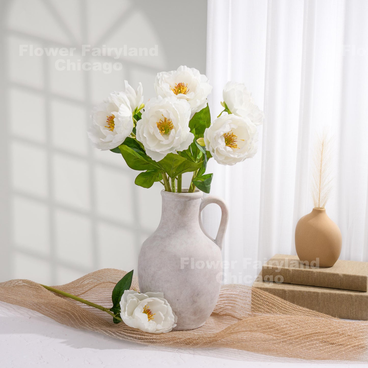 White faux peonies styled in a pitcher vase